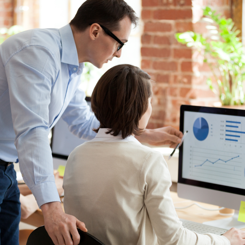 Woman and man looking at computer dashboard and reporting together